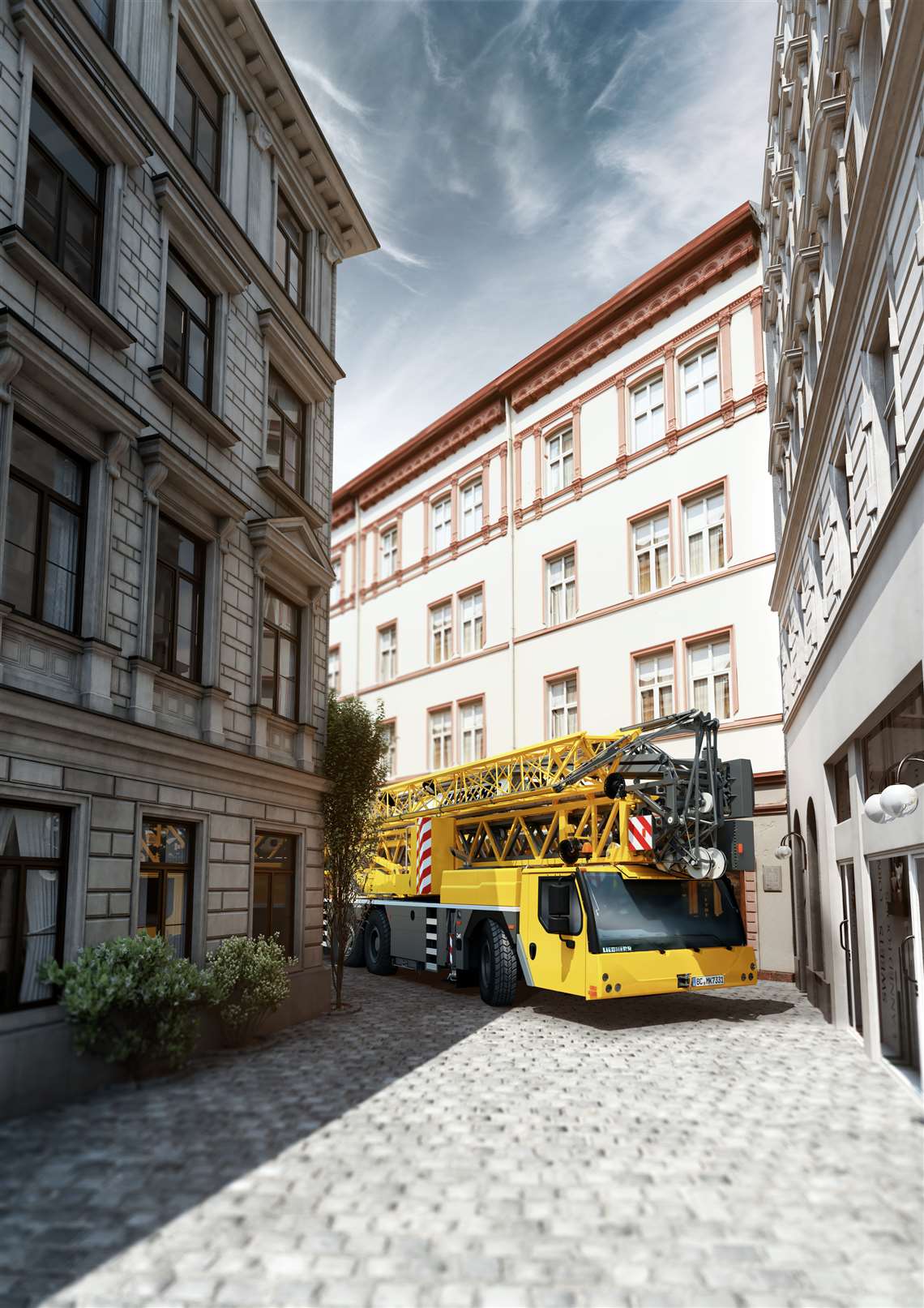 Liebherr's MK 73-3.1 mobile folding construction crane in yellow negotiating a narrow city street
