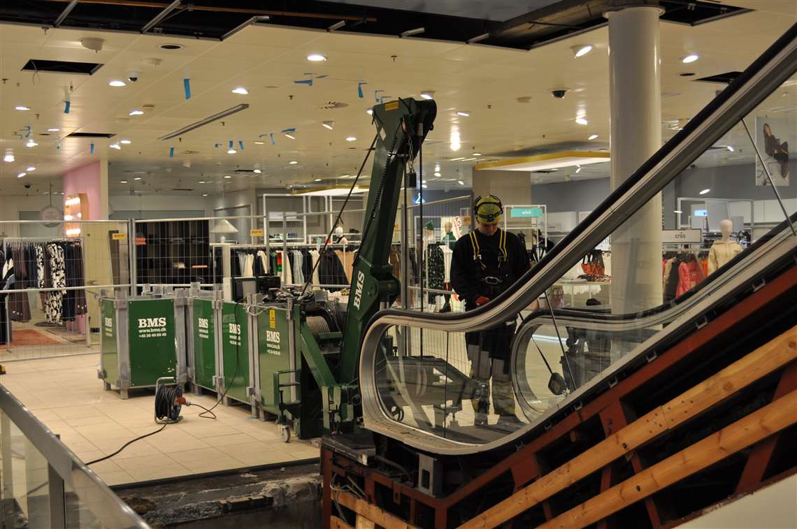 Green crane in application installing an escalator