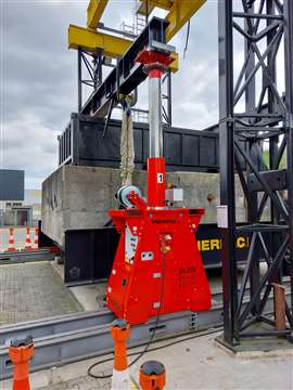 red Enerpac SL 200 hydraulic telescopic lifting gantry units set up with a black beam underneath a larger yellow and black Enerpac gantry tower system