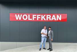 Ralph Stump and Rodolphe Roche shake hands under a Wolffkran sign