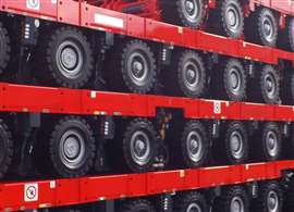 red trailers with black tyres and silver wheels stacked on top of each other