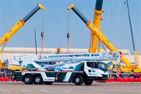 Side view of white painted truck crane with turquoise accents and prominent EV lettering