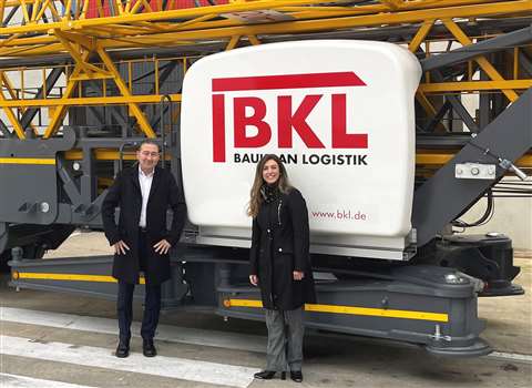 Man and woman standing in front of a crane with BKL logo on it