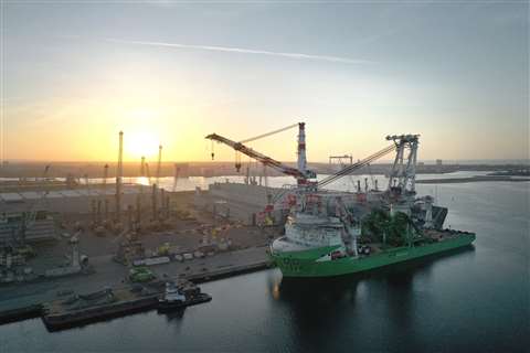 Susnset behind green ship with big crane