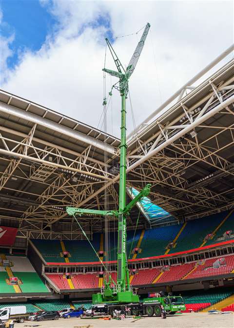 green Liebherr crane erected in a sports stadium