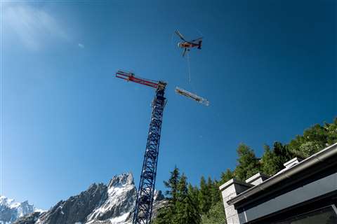 helicopter adds a part of a tower crane in french mountain