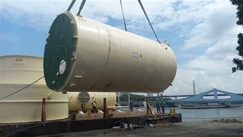 A 15 tonne tank being hoisted onto a barge. 