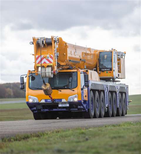 The new Demag AC 450-7 in blue and yellow Demag livery, boom down, travelling, front three quarter view