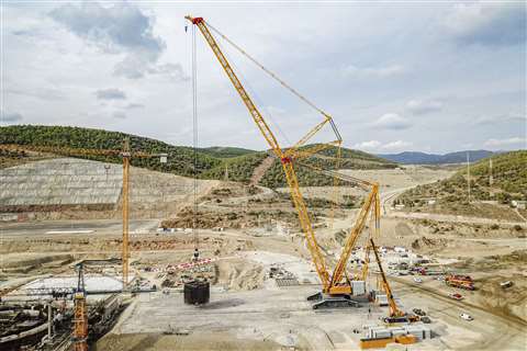 Liebherr claims its LR 13000 as the most powerful conventional crawler crane in the world. Pictured is a distant shot of a yellow one lifting something in what looks like a quarry